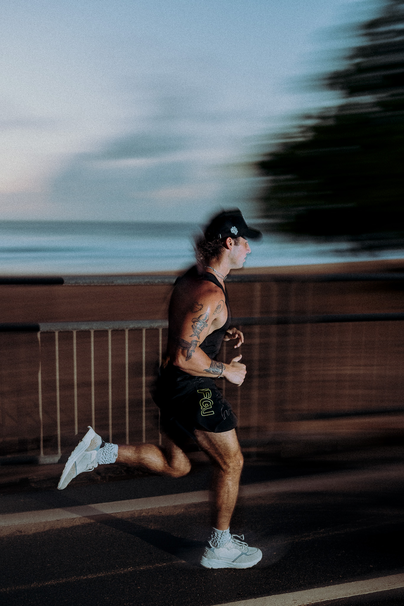 Side-profile runner along a coastal boardwalk near the race course