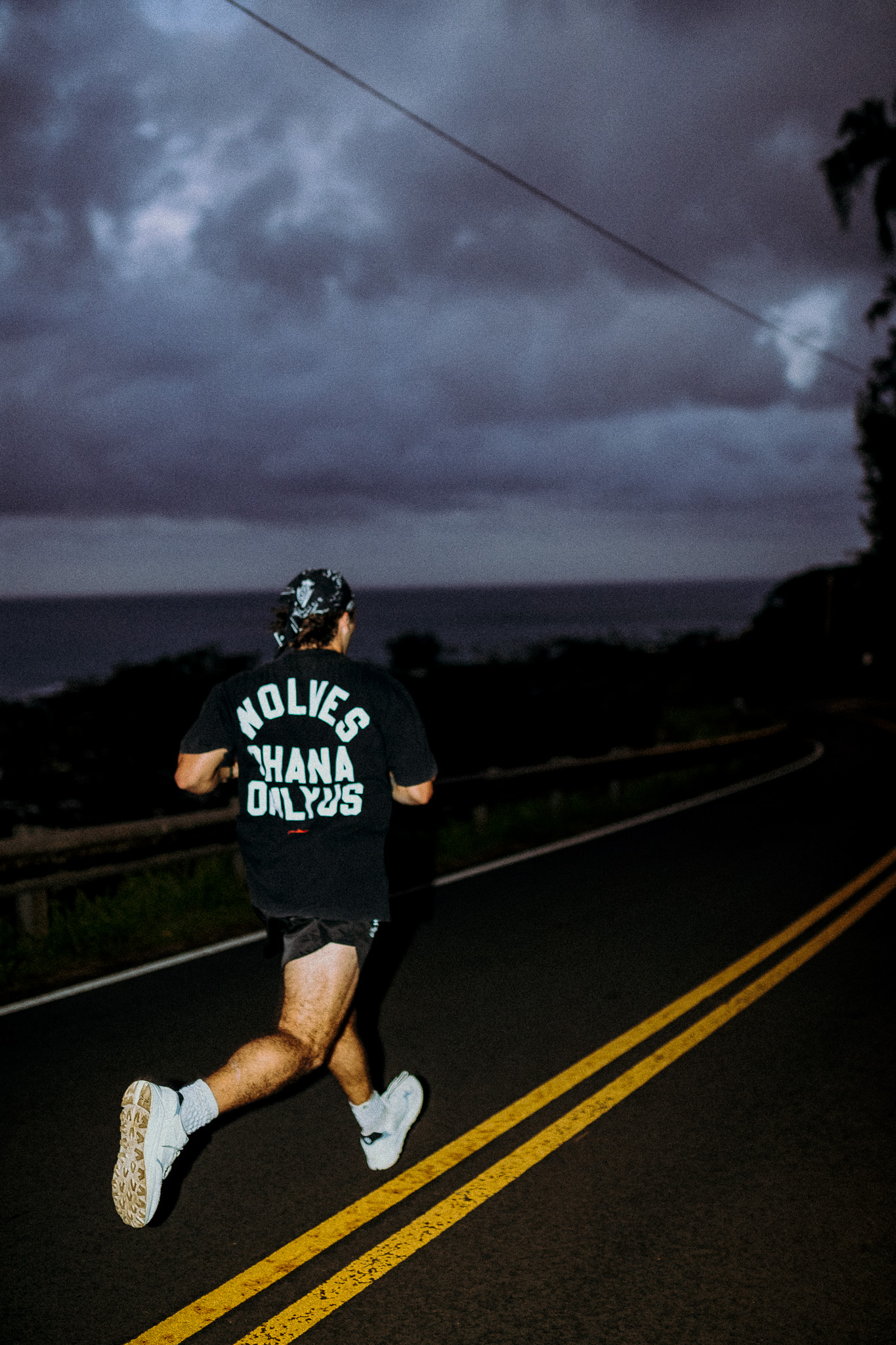Runner from behind on an open road at dusk