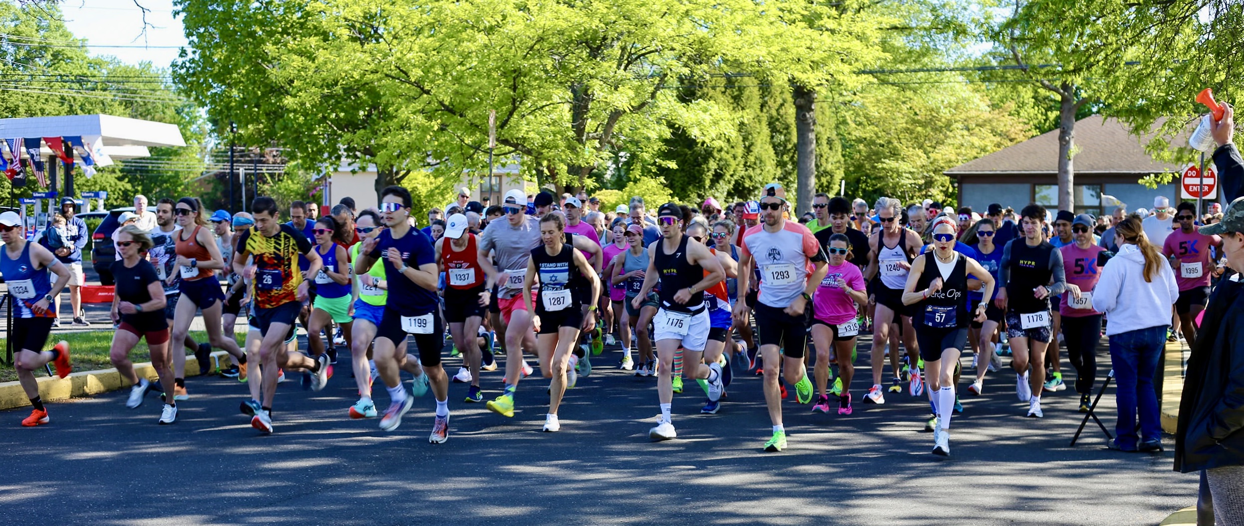 A large field of runners of all ages at the YMCA Bucks County Strong 5K start line on a sunny morning
